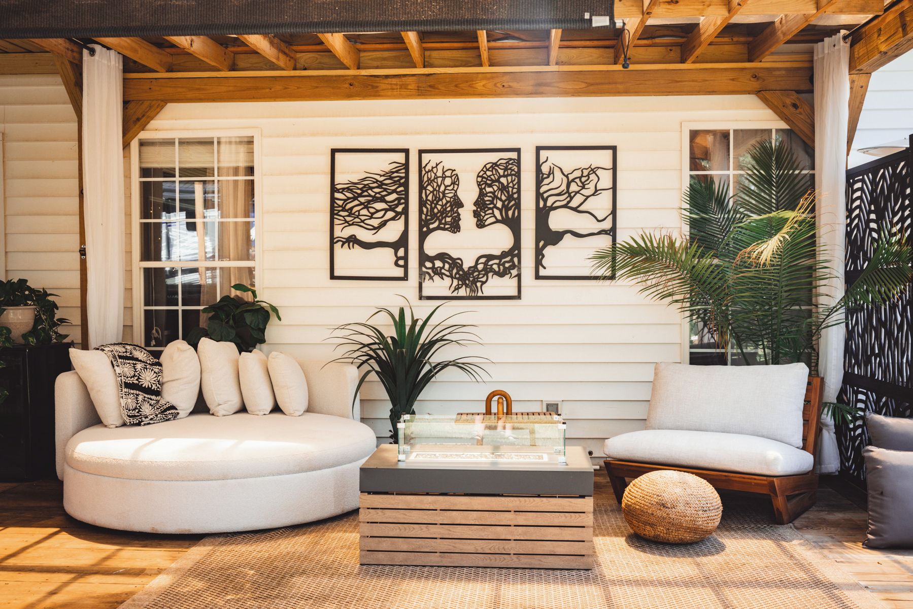 A cozy living room with a white sofa, a wooden coffee table, and three framed wall art pieces.