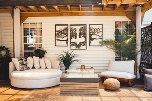 A cozy living room with a white sofa, a wooden coffee table, and three framed wall art pieces.