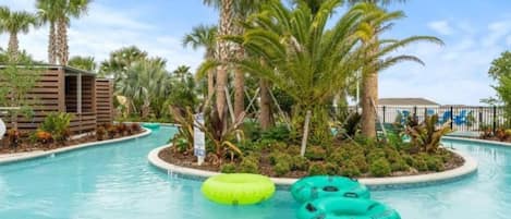 A swimming pool with palm trees and inflatable rings.