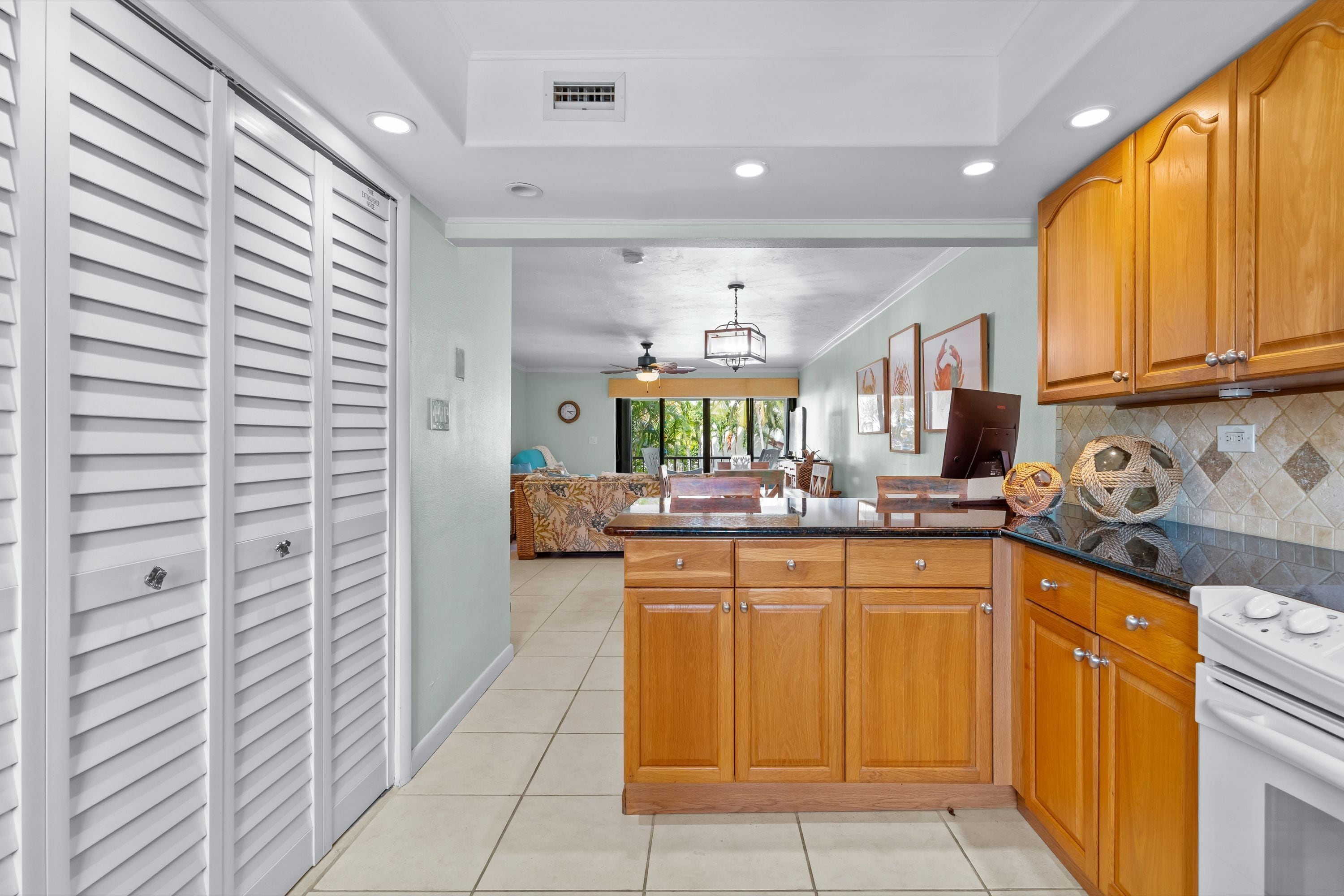 A kitchen with wooden cabinets, a countertop, and a stove.