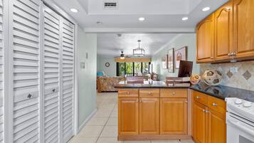 A kitchen with wooden cabinets, a countertop, and a stove.