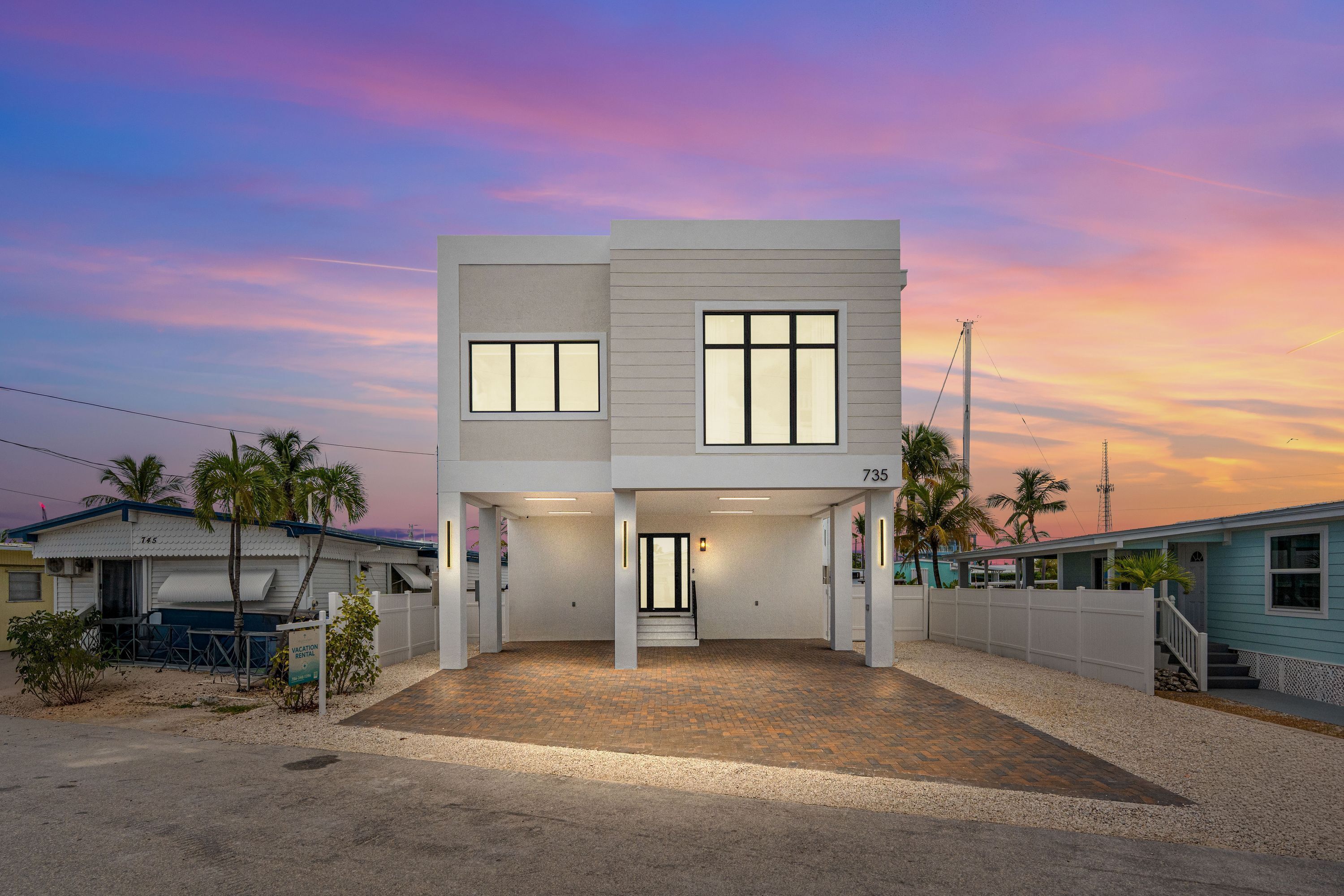 A two-story modern house with a covered driveway and a small front porch.