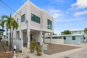 A modern two-story building with a covered entrance and a clear sky. - Cielo del Mar - Waterfront - Heated Pool - Dock (Marathon)