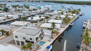 A marina with multiple boats, a swimming pool, and residential buildings.