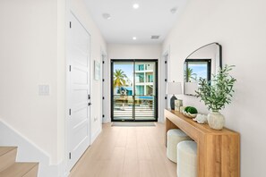 A hallway with a wooden bench, a mirror, and a potted plant. - Cielo del Mar - Waterfront - Heated Pool - Dock (Marathon)