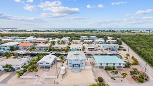 A coastal residential area with houses, a marina, and a clear view of the ocean. - Catch of the Bay - Waterfront - Pool - 35 Dock (Marathon)