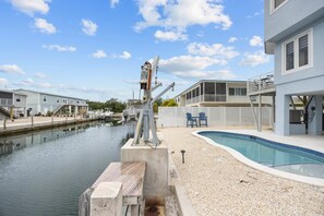 A residential area with a swimming pool, a dock, and a boat. - Catch of the Bay - Waterfront - Pool - 35 Dock (Marathon)