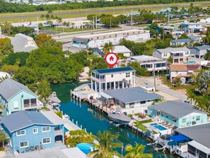 A coastal residential area with houses, a marina, and a large body of water. - The Salty Coconut Waterfront Dock Hot Tub (Marathon)