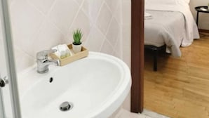 A bathroom with a white sink, a mirror, and a wooden door.