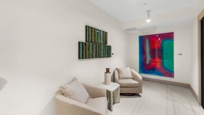 Ein modernes Interieur mit zwei Sofas, einer Vase und abstrakter Wandkunst.