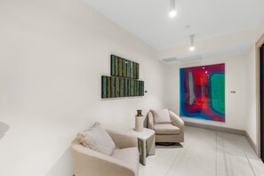 Ein modernes Interieur mit zwei Sofas, einer Vase und abstrakter Wandkunst.