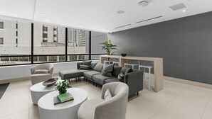 Ein modernes Wohnzimmer mit einer Eckcouch, einem Couchtisch und einem Beistelltisch. Ein großes Fenster bietet Blick auf die Stadtlandschaft.