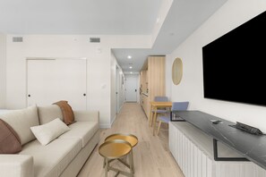 Un salon moderne avec un canapé, une table basse et un téléviseur fixé au mur.