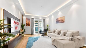 A modern living room with a sofa, a TV, and a view of the cityscape through the window. - Stayshort - Modern 2BR Apartment in Sulafa Tower Dubai Marina Near to Beach JBR - Sleeps 6 (Dubai)