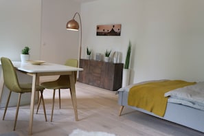 Ein stilvoller Wohnraum mit Essbereich, einem Bett und einem Gemälde an der Wand.
