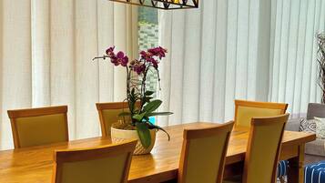 Un comedor con una mesa de madera, sillas amarillas y una lámpara colgante.