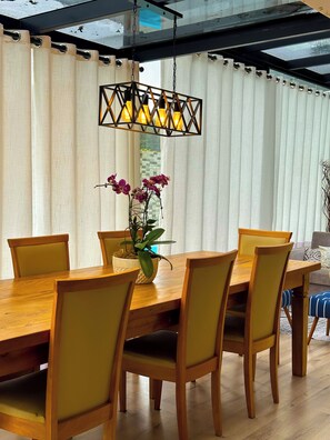 A dining area with a wooden table, yellow chairs, and a hanging light fixture.