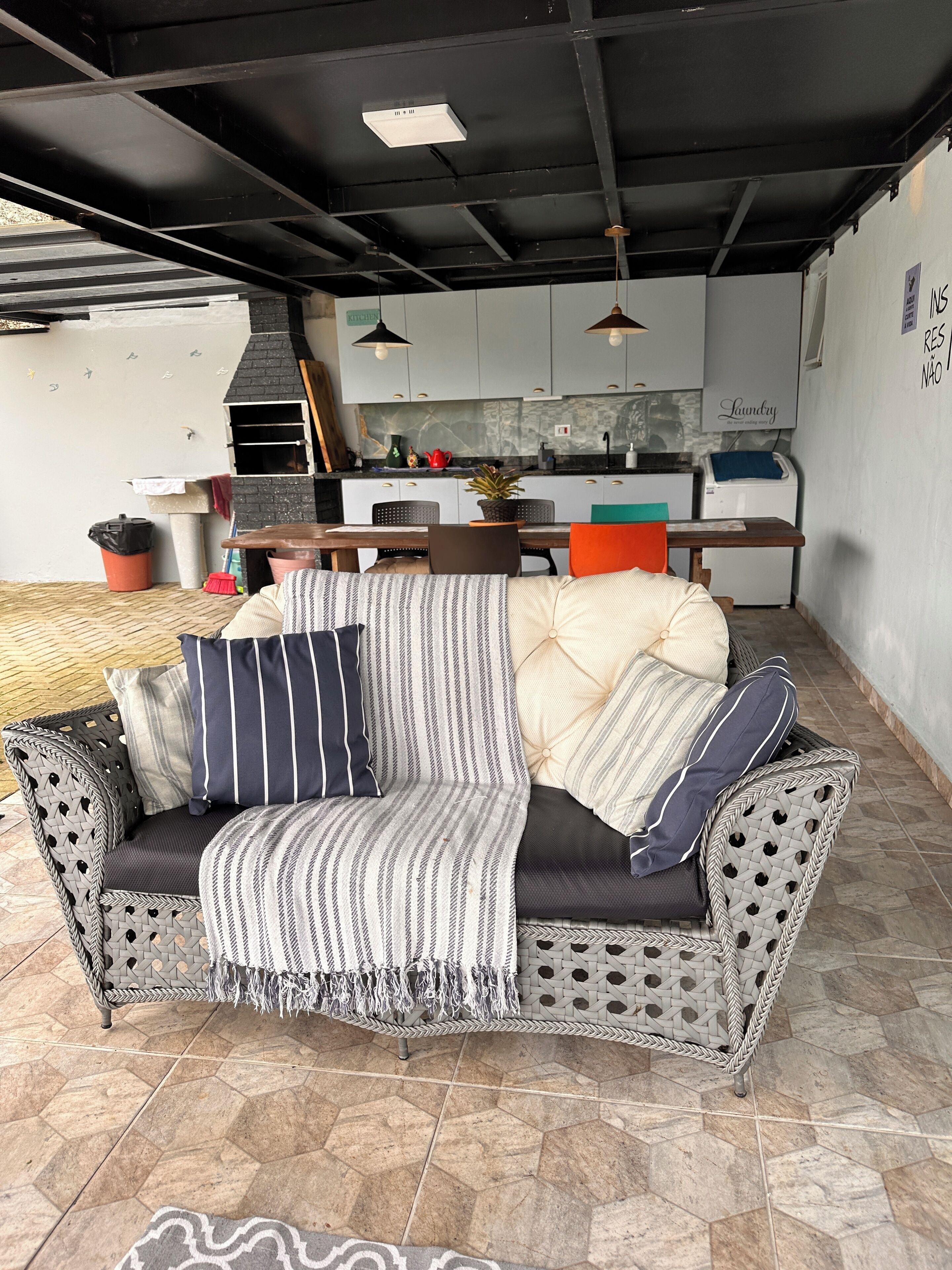 A modern living area with a sofa, dining table, and kitchen in the background.