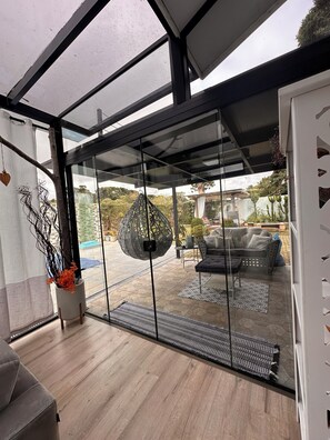 A modern interior with a glass door leading to an outdoor patio area.
