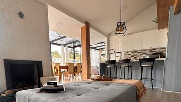 Una sala moderna con un sofá seccional gris, una chimenea y un comedor con una mesa y sillas de madera.