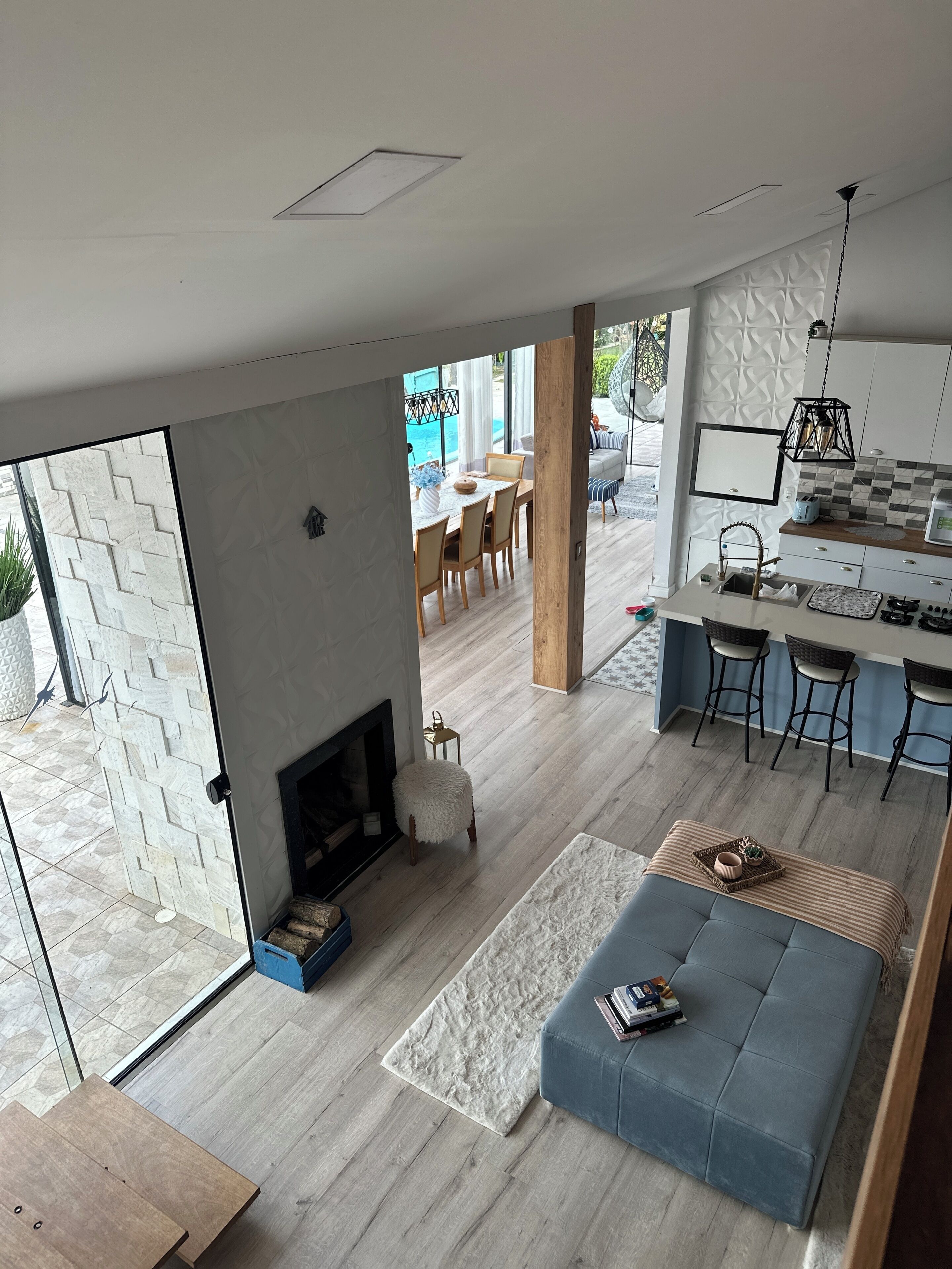 Una sala de estar moderna con chimenea, un comedor y una cocina con taburetes de bar.