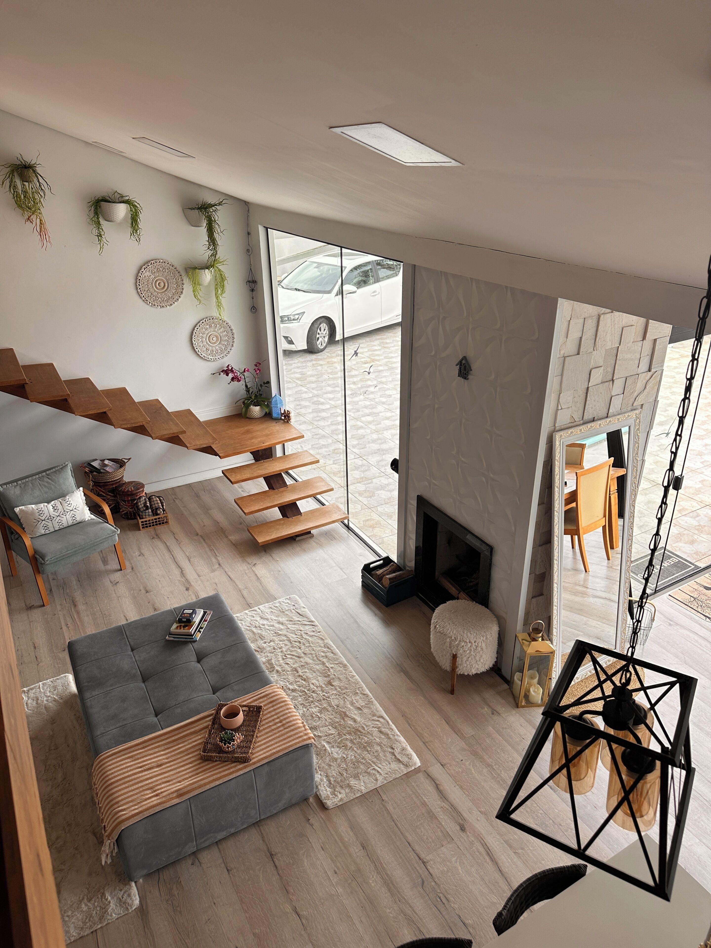 A modern living room with a sofa, a fireplace, and a view of the outside.
