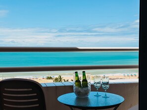 A balcony with a view of the beach, a table with two bottles and two glasses. - Terrazo Ponta Negra by Almare (Natal)