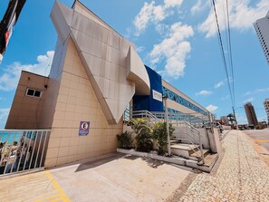 A modern building with a prominent blue and beige facade, a visible entrance, and a staircase leading to the entrance. - Terrazo Ponta Negra by Almare (Natal)