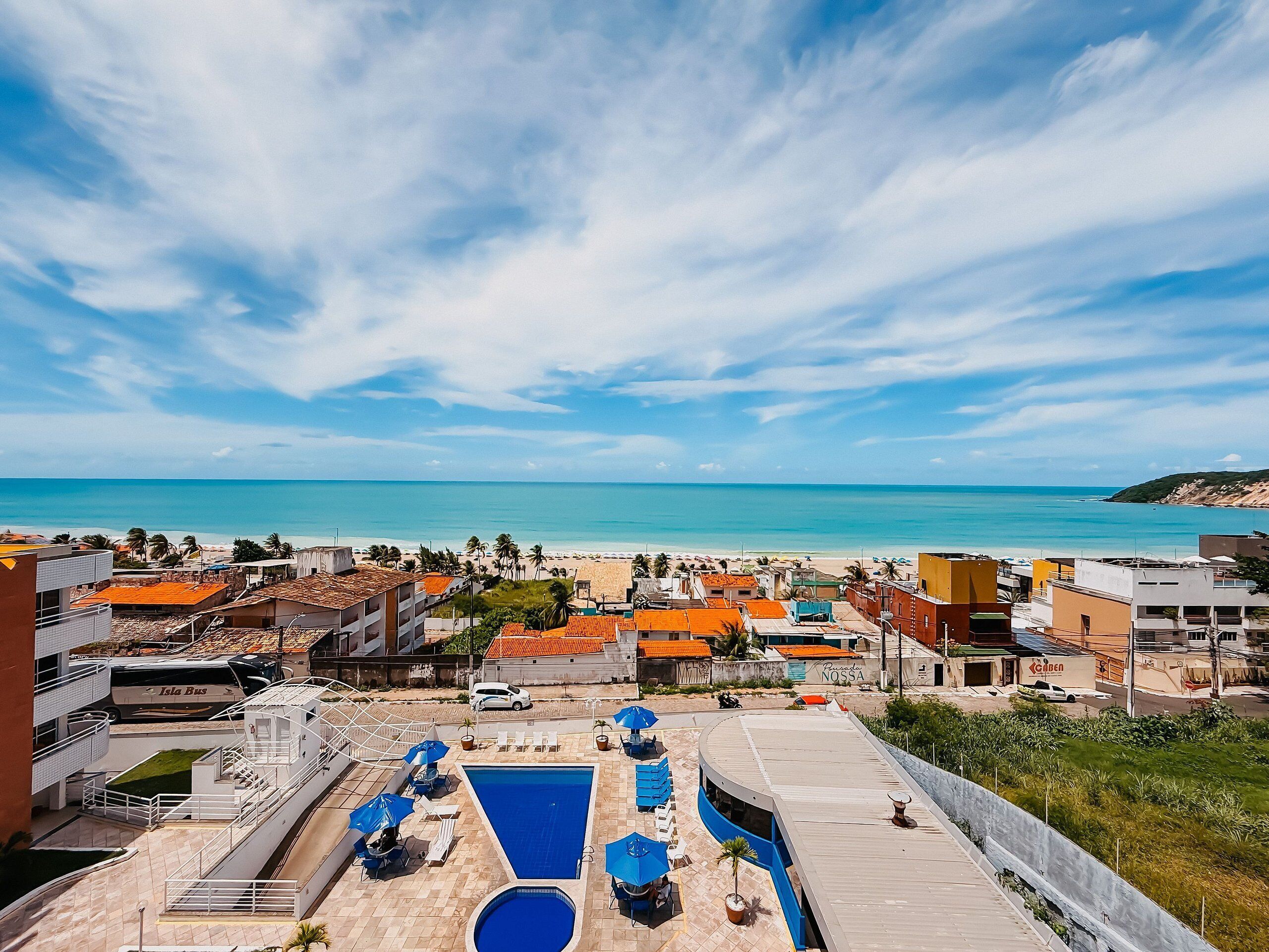 Un espace piscine aménagé sur le toit, offrant une vue sur la plage et l’océan.