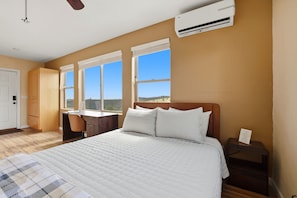 A bedroom with a bed, a desk, and a chair. There is an air conditioning unit on the wall. - Cozy 1BR casita with stunning panoramic views (Prescott)