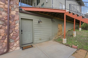 A house with a stone exterior, a grey door, and a small porch with a red railing. - Cozy 1BR casita with stunning panoramic views (Prescott)