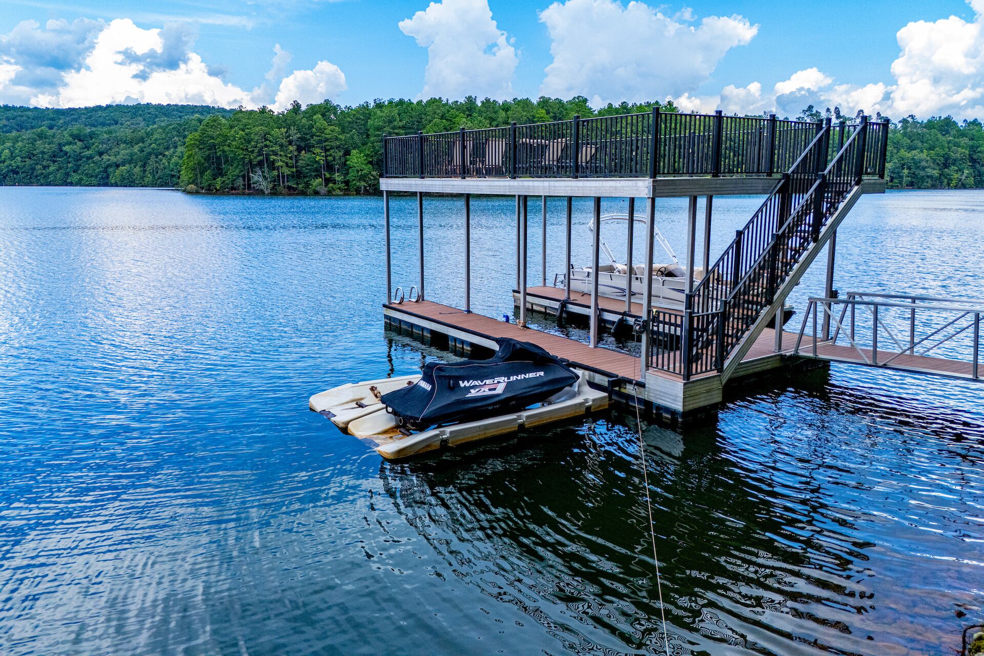 A dock with a boat and a covered seating area.