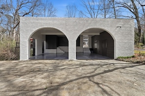 A modern building with two arched entrances and a concrete driveway. - The Chateau Elan of Atlanta with Courtyard Hot tub (Atlanta)