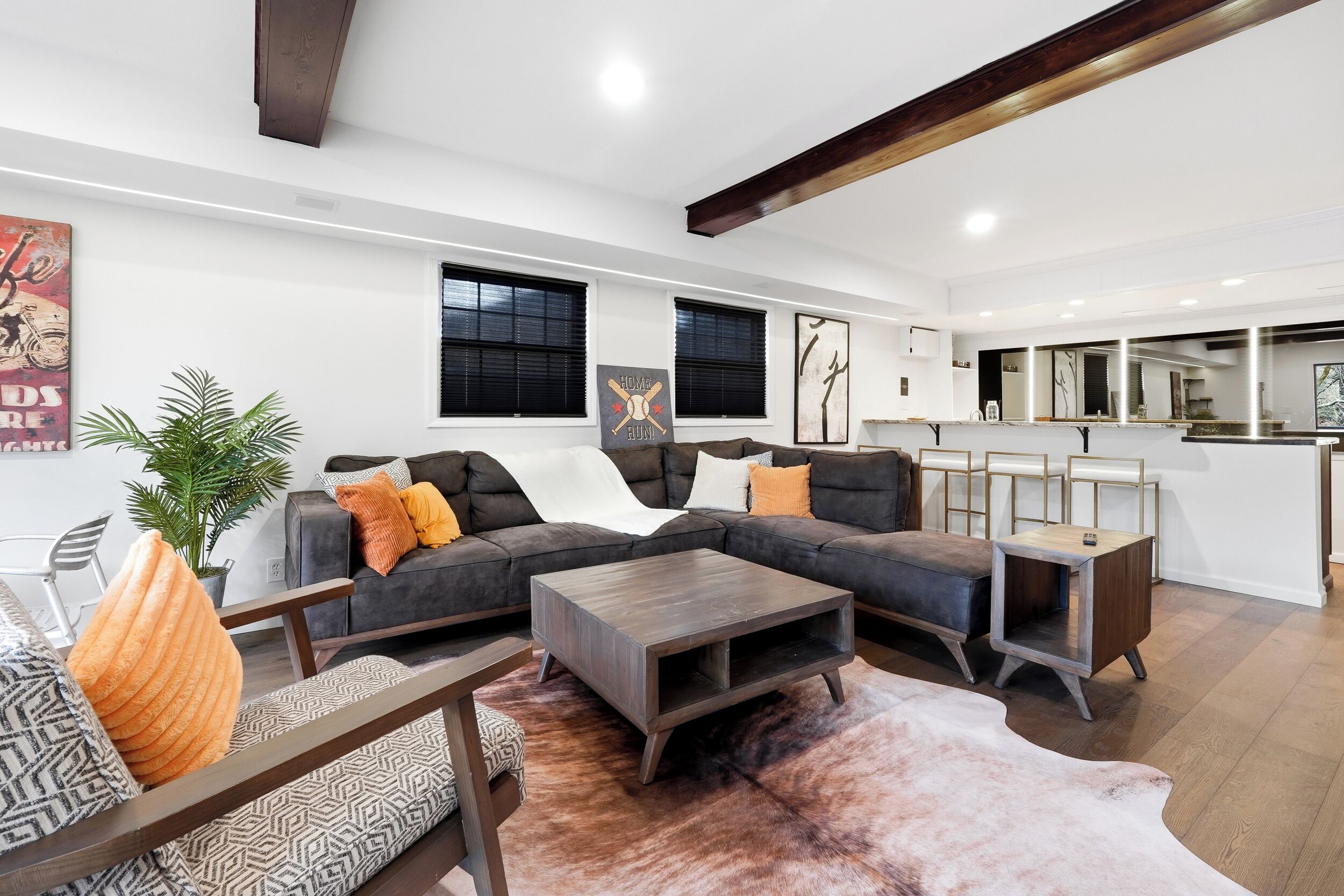 A modern living room with a sectional sofa, a coffee table, and a large mirror.