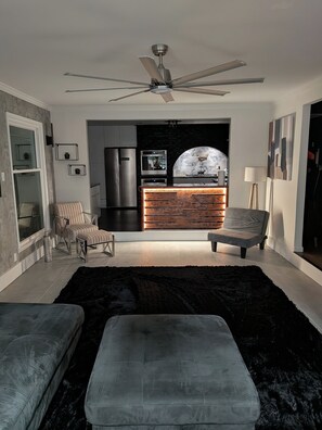 A modern living room with a black rug, two grey sofas, a wooden coffee table, and a ceiling fan. - The Chateau Elan of Atlanta with Courtyard Hot tub (Atlanta)