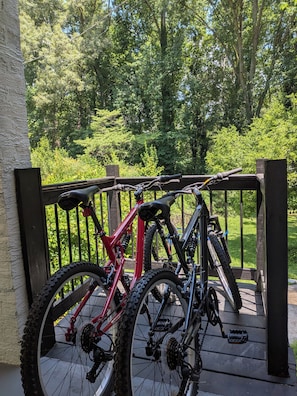A bicycle parked on a wooden deck with a railing, surrounded by greenery. - The Chateau Elan of Atlanta with Courtyard Hot tub (Atlanta)