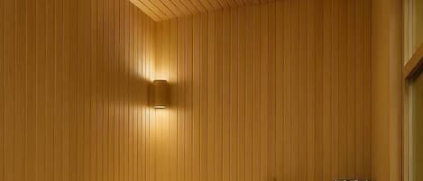 A sauna with wooden benches and a glass cabinet.