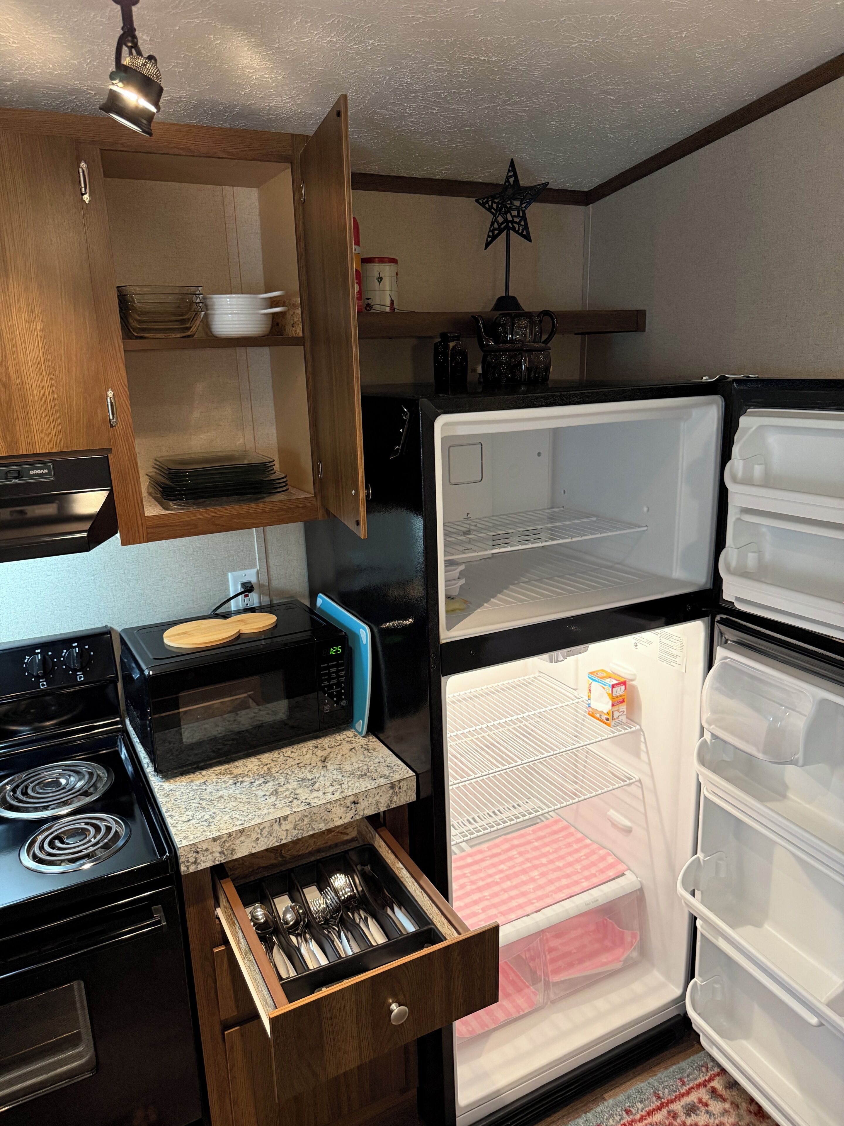 A compact kitchen with a microwave, stove, and refrigerator.