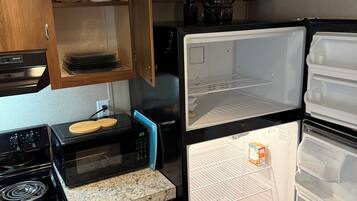 A compact kitchen with a microwave, stove, and refrigerator.