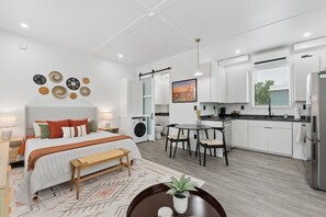 A modern bedroom with a bed, bedside tables, and a bedside lamp. - Modern Boxabl Casita | Stillwater OK | Pasadera 4 (Stillwater)