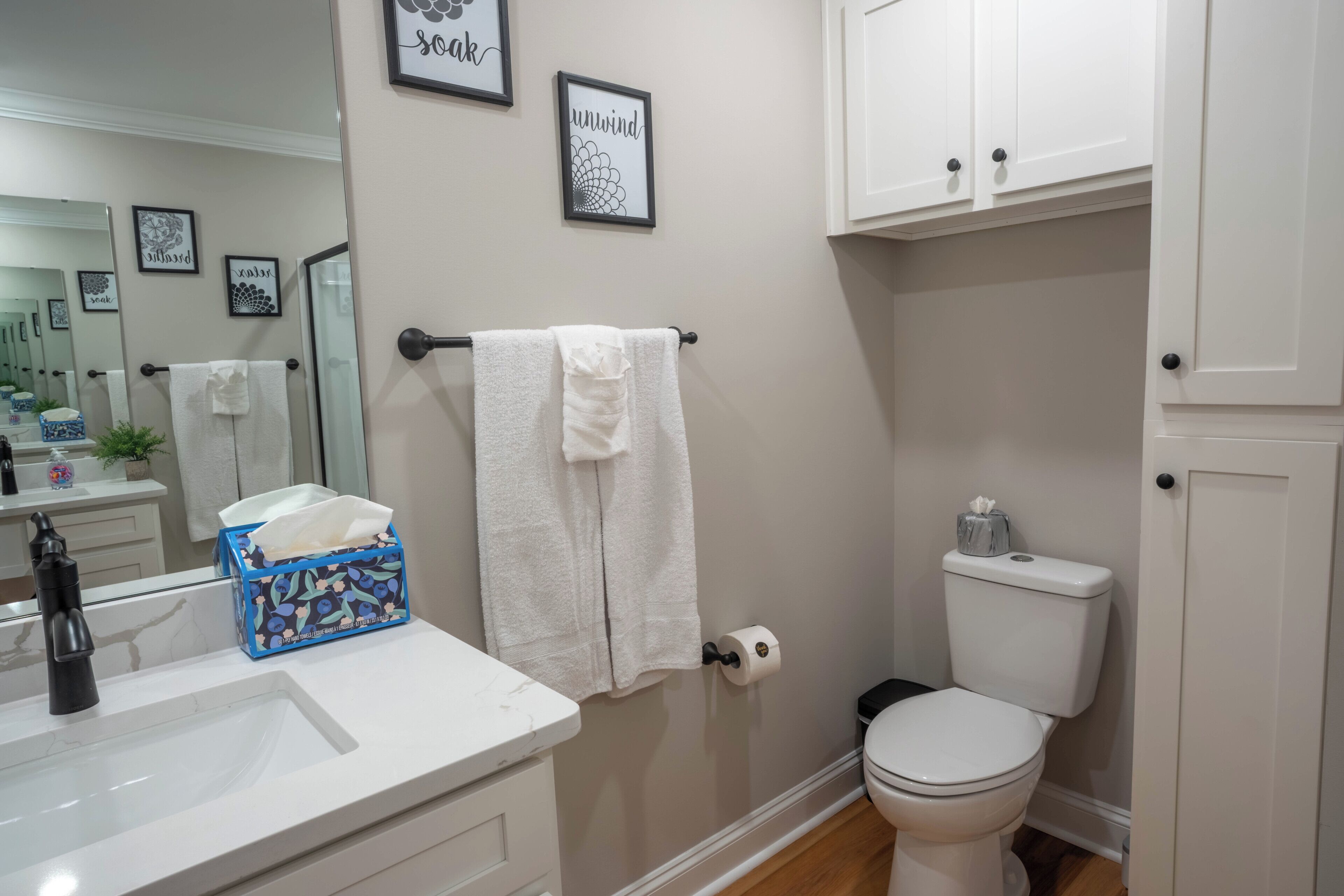 Een badkamer met een witte wastafel, een toilet en een handdoekhouder.