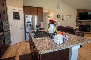 A modern kitchen with granite countertops, stainless steel appliances, and a central island.