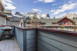 Ein Balkon mit Grill und Blick auf ein Gebirge.