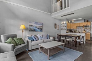 Ein modernes Wohnzimmer mit Sofa, Couchtisch und Essbereich.
