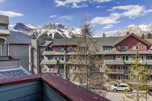 Ein Hotel mit mehreren Etagen, Balkonen und Blick auf schneebedeckte Berge.