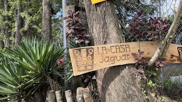 A wooden sign with text, attached to a tree, and a yellow sign indicating private property.