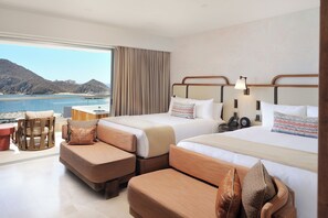 A hotel room with two beds, a sofa, a small table, and a view of the sea. - Comfort and Relaxation! Oceanfront, Infinity Pool, Pet-friendly, Free Parking! (Cabo San Lucas)