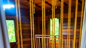 A wooden interior with a rope barrier, a window with a view, and a ceiling light.