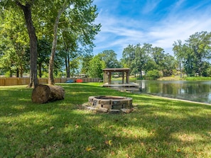 A tranquil park with a wooden gazebo, a stone fire pit, and a pond. - Lakefront Oasis: Pool, Fire Pit, Kayak, Paddle Boards, Game Room (Hot Springs)
