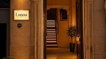 The entrance to the Lunera Hotel with a classic arched doorway, a staircase leading inside, and a sign above the door.